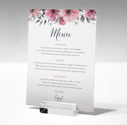 wedding table menu with pink flowers in a glass stand