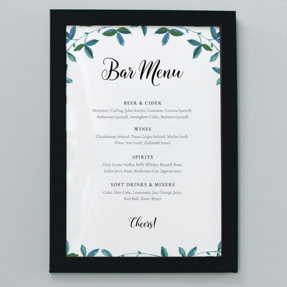 A2 outdoor wedding bar menu with green foliage in a black frame
