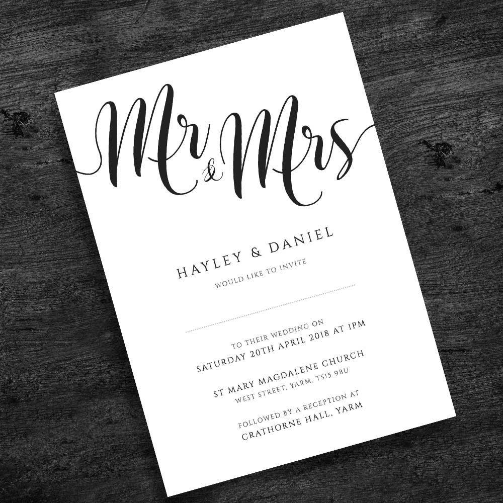 black and white wedding invitation on rustic wood background