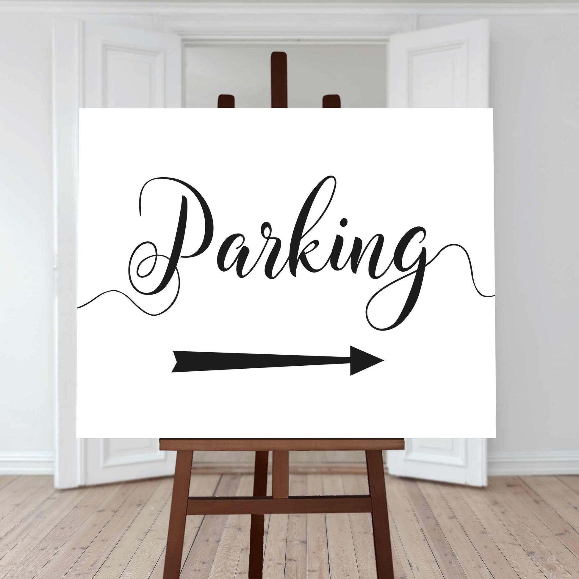 printed parking sign with directional arrow on white card standing on an easel