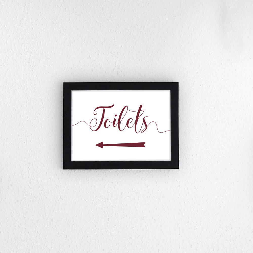 burgundy directional toilets sign with left arrow printed and framed