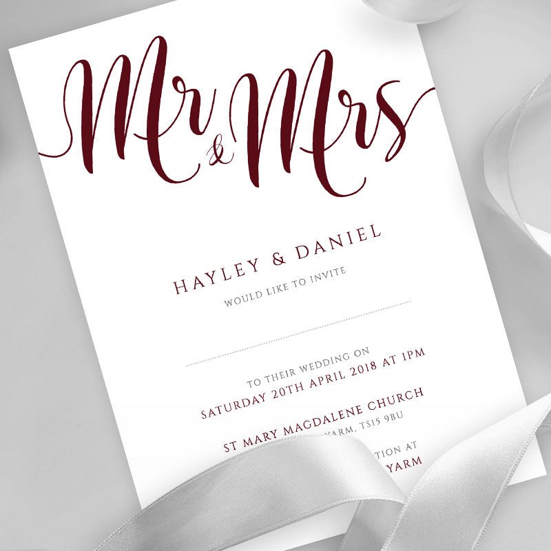 burgundy wedding invitation printed on white card with ribbons overlayed