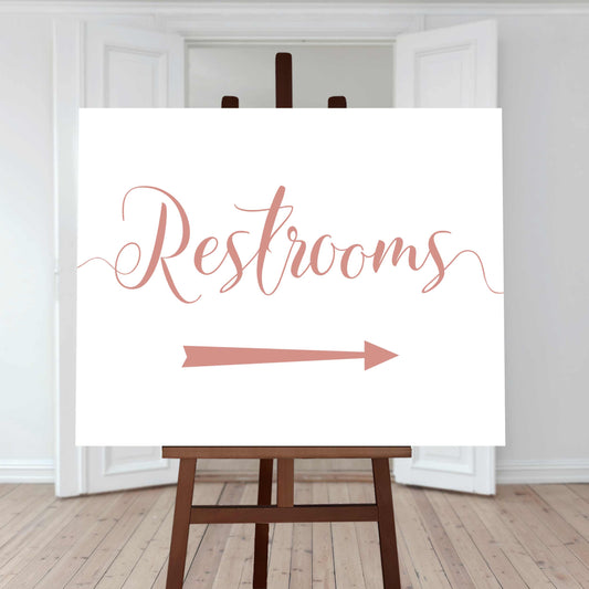 coral restroom directions sign with an arrow pointing right