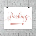 coral parking lot arrow sign hanging from a wall