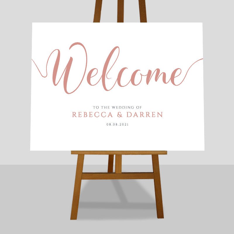coral wedding welcome sign on an easel