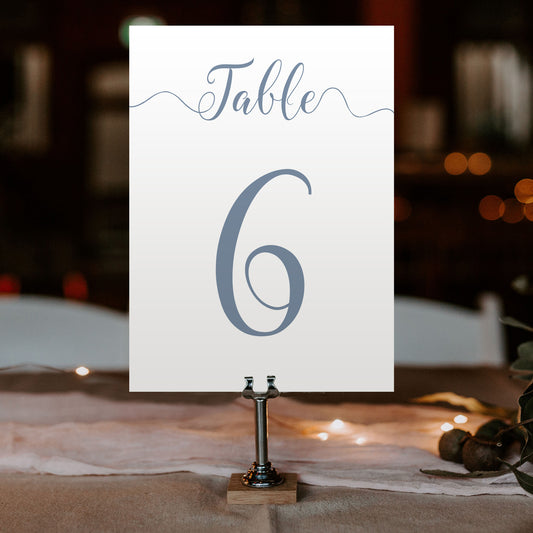 dusty blue table number on a wedding table at an evening reception