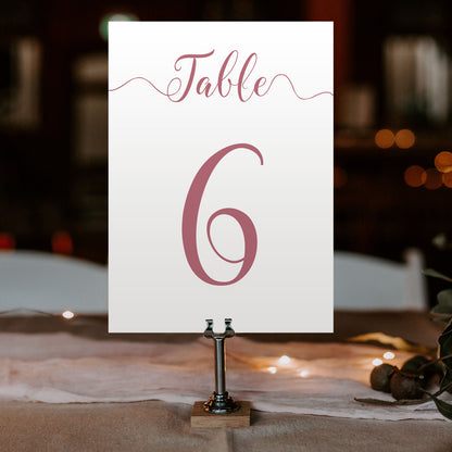 dusty pink table number on a wedding table at an evening reception