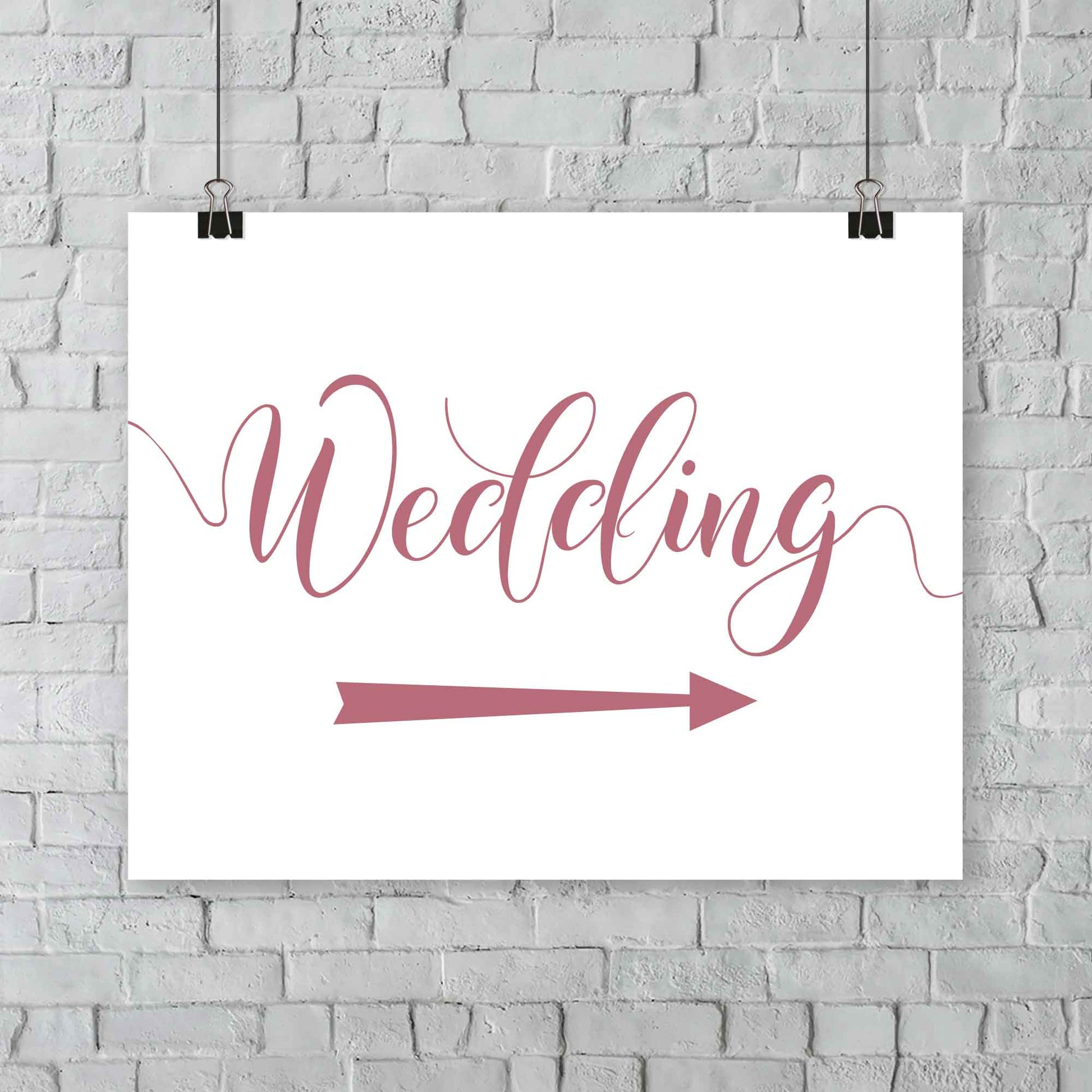 dusty pink wedding arrow sign print hanging from a wall