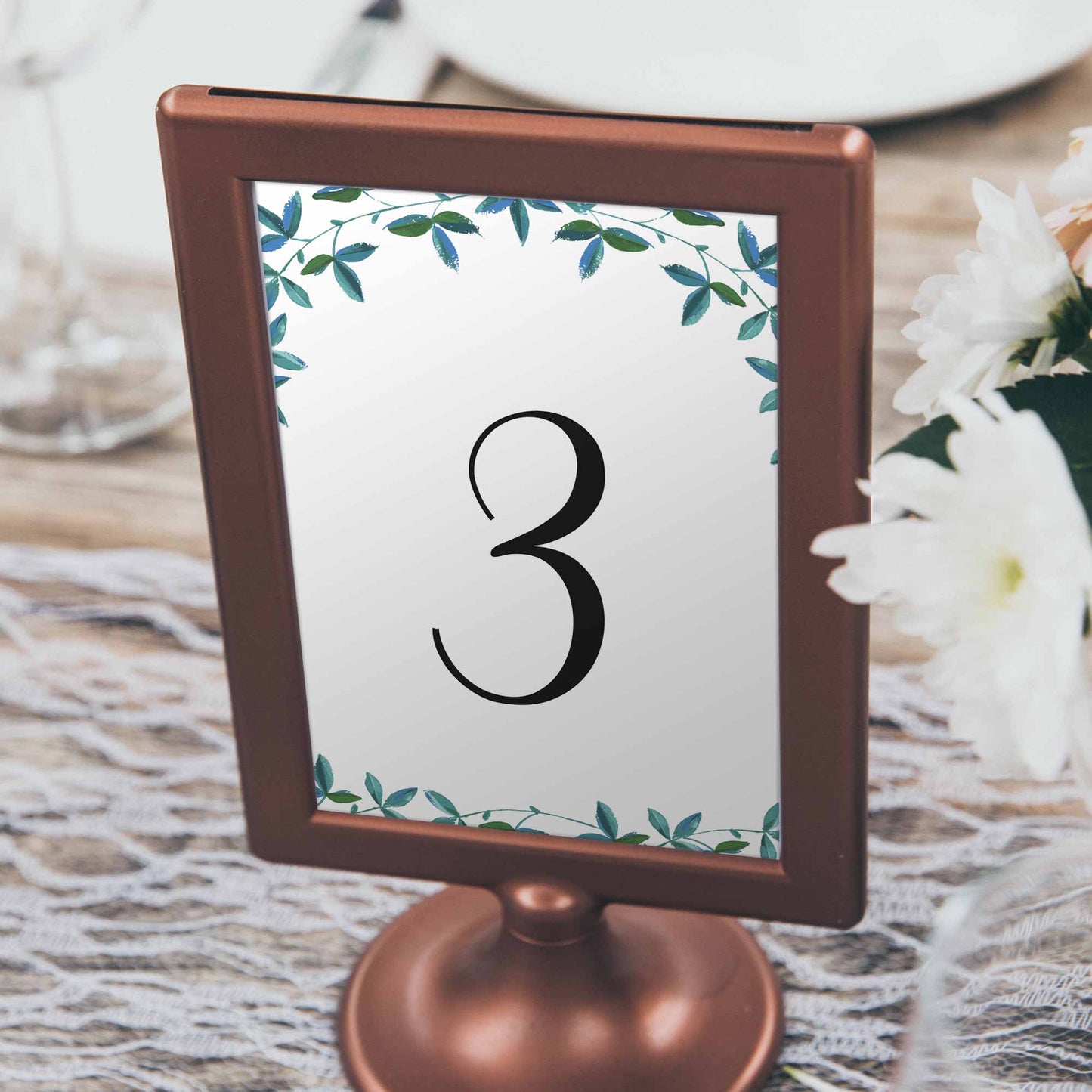 printed table number with eucalyptus leaves in a frame on a boho wedding table
