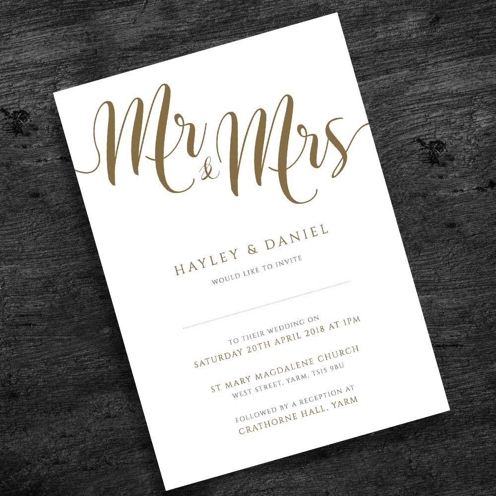 gold wedding invitation on rustic wood background