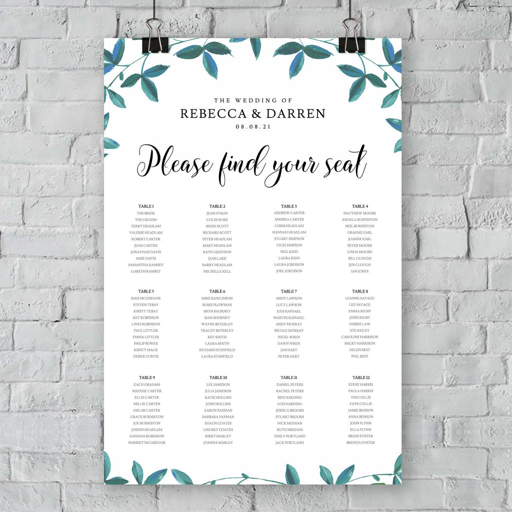 seating chart with 12 tables and green foliage border hanging from an exterior wall
