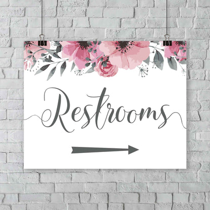 boho restrooms arrow sign hanging from an outdoor wedding wall