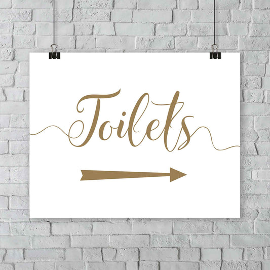 gold toilets arrow sign at outdoor wedding