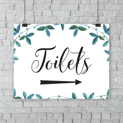 toilets arrow sign with green foliage hanging from an outside wall