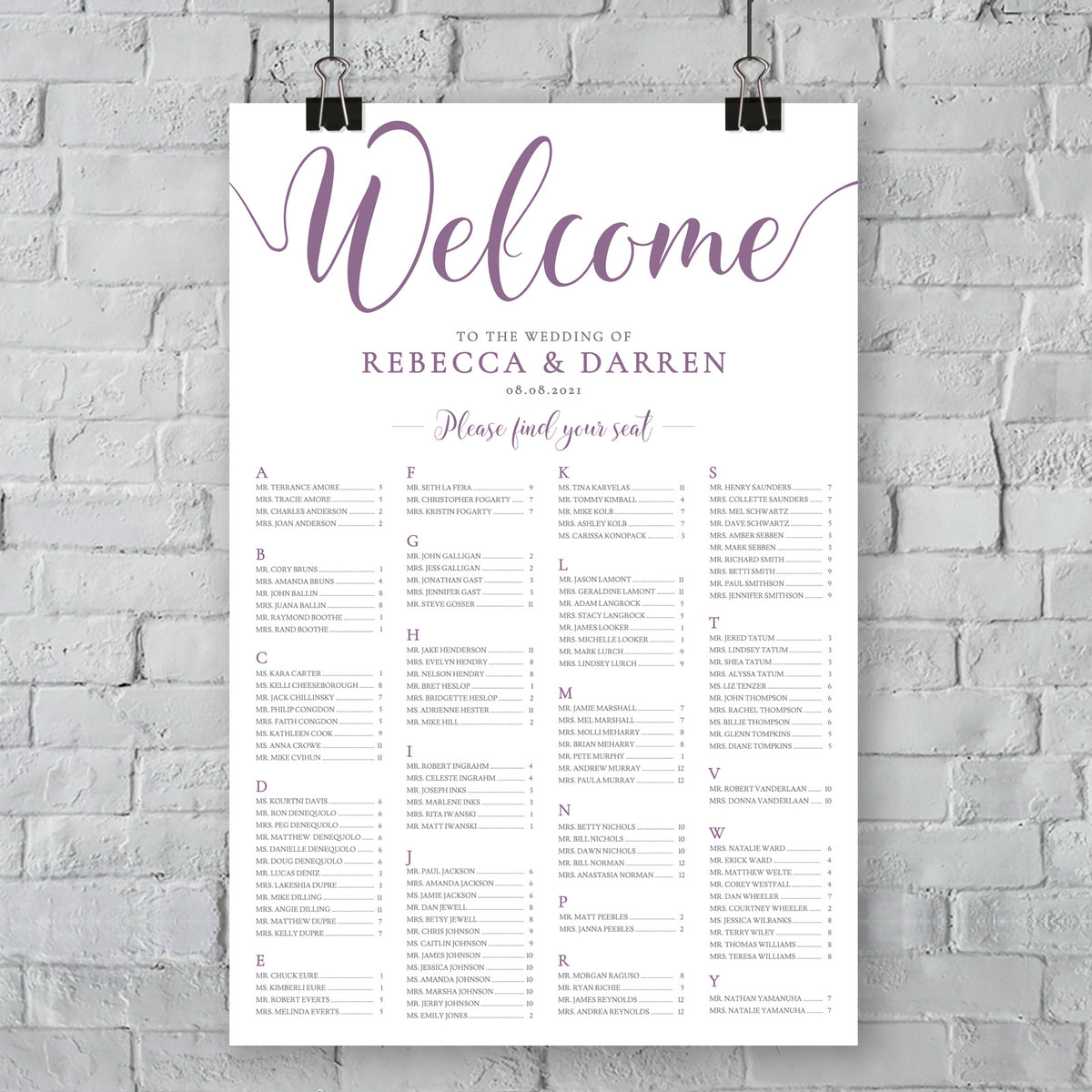 large print of purple wedding seating chart on wall