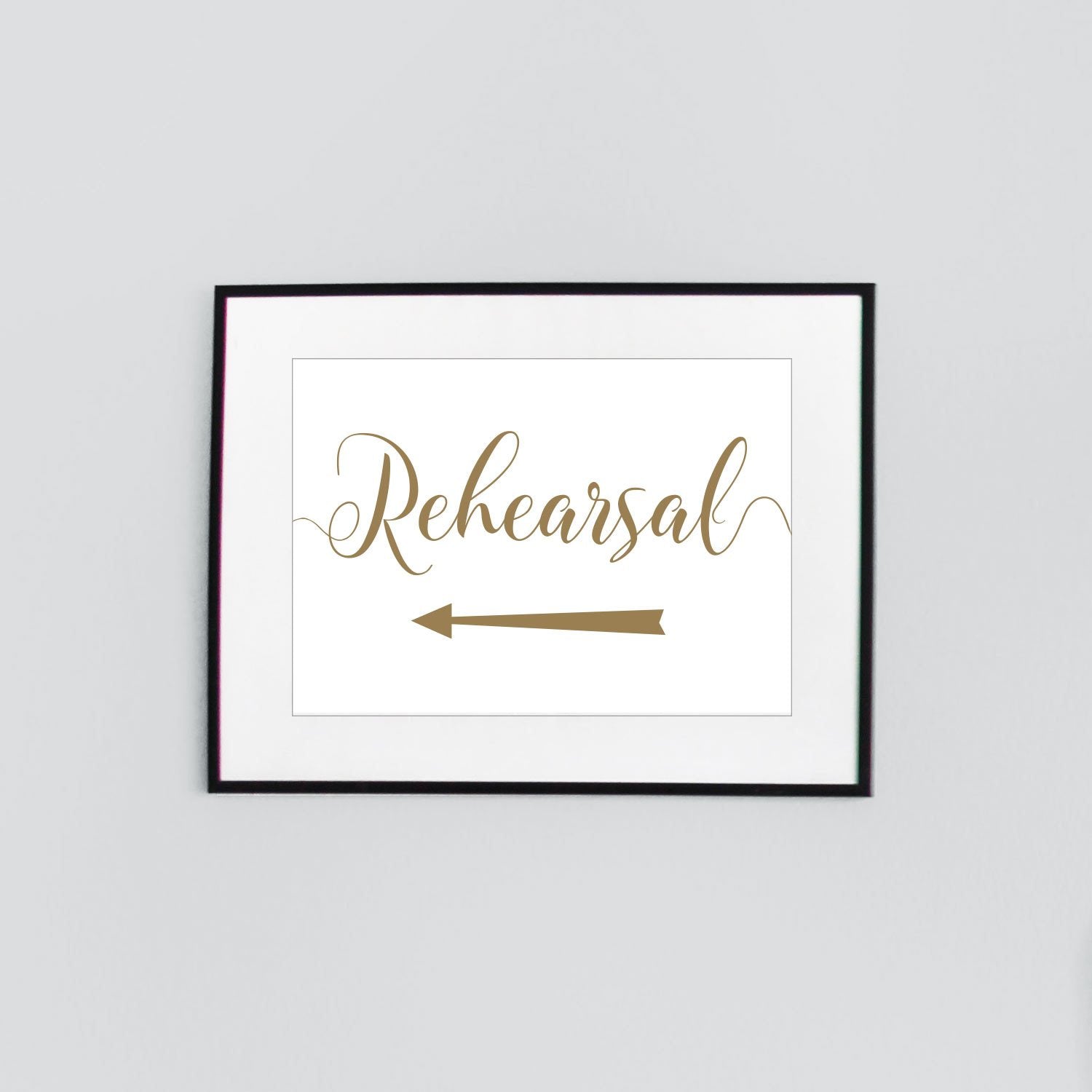 gold wedding rehearsal sign with left arrow