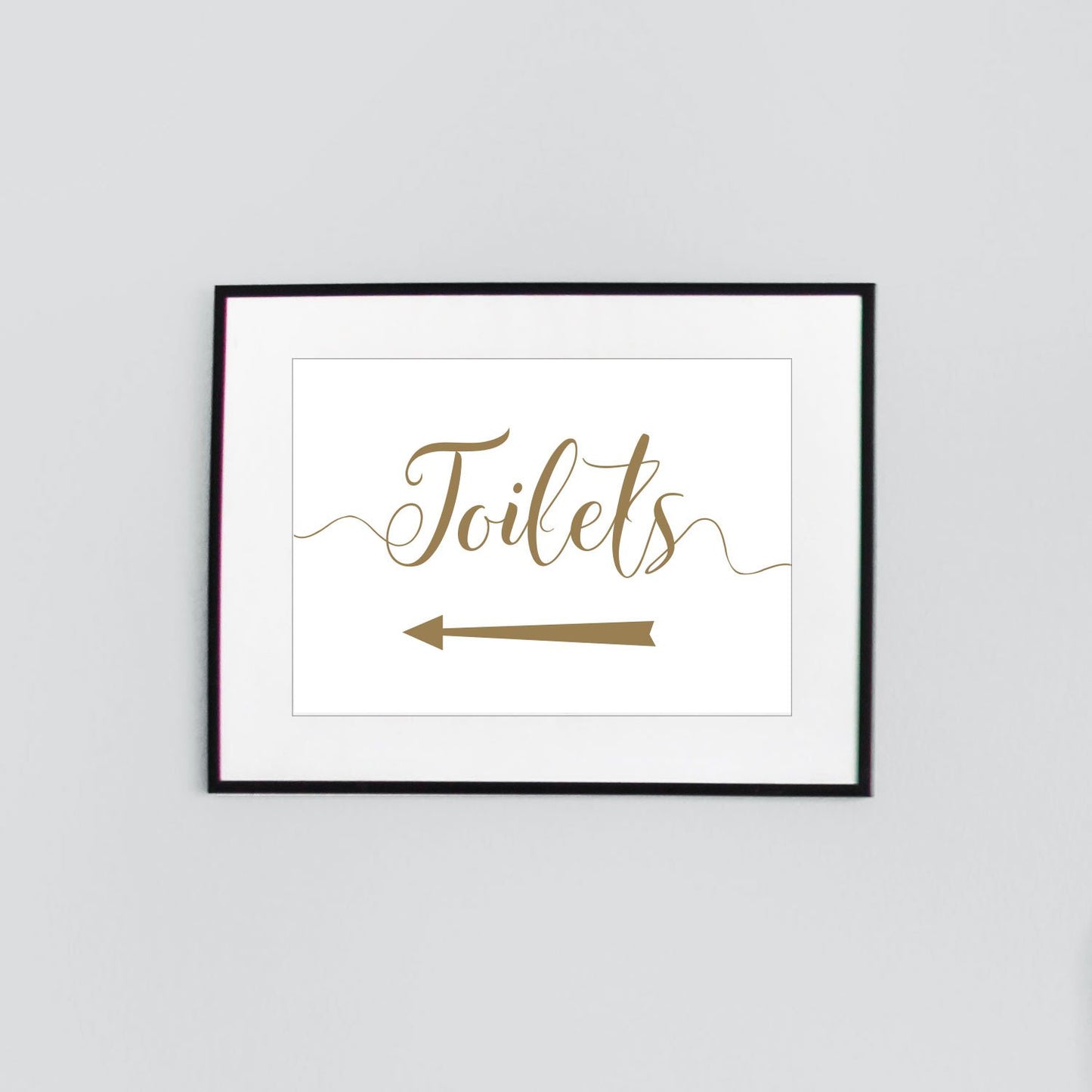 framed toilets sign with gold text and left arrow