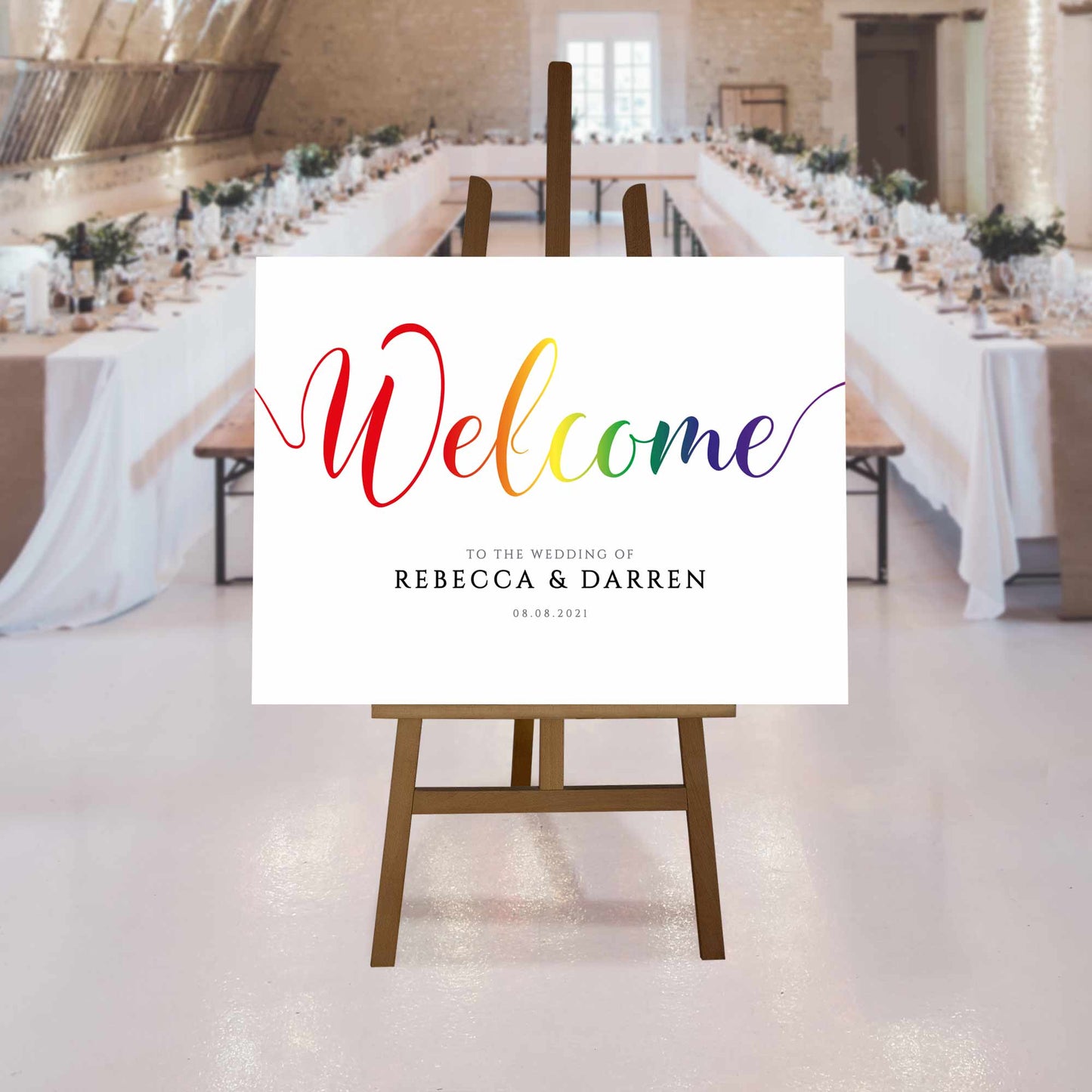 printed pride rainbow welcome sign at a rustic wedding reception