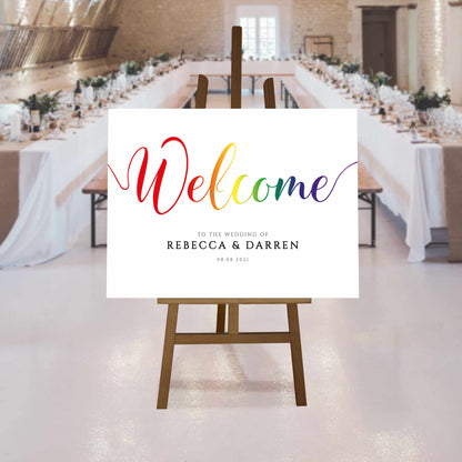 printed pride rainbow welcome sign at a rustic wedding reception