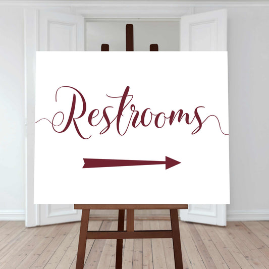 maroon restroom directions sign with an arrow pointing right