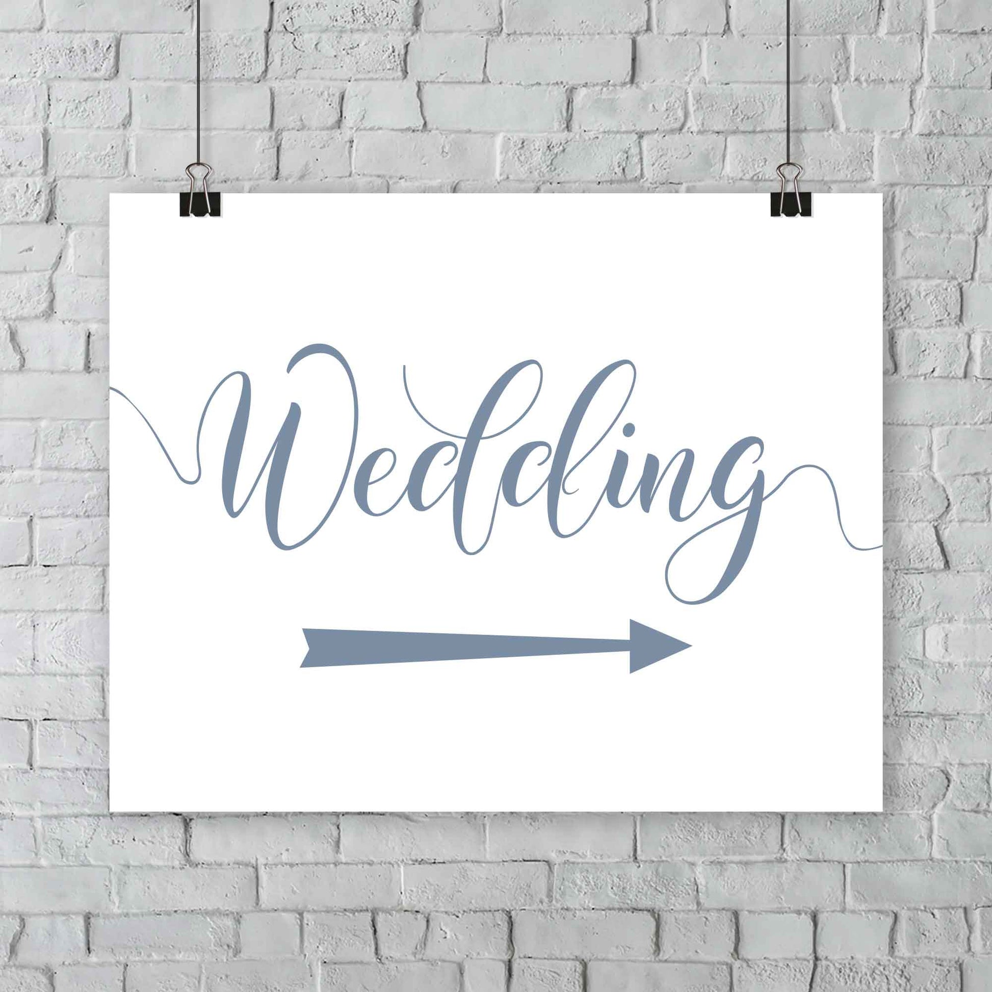 misty blue wedding arrow sign print hanging from a wall