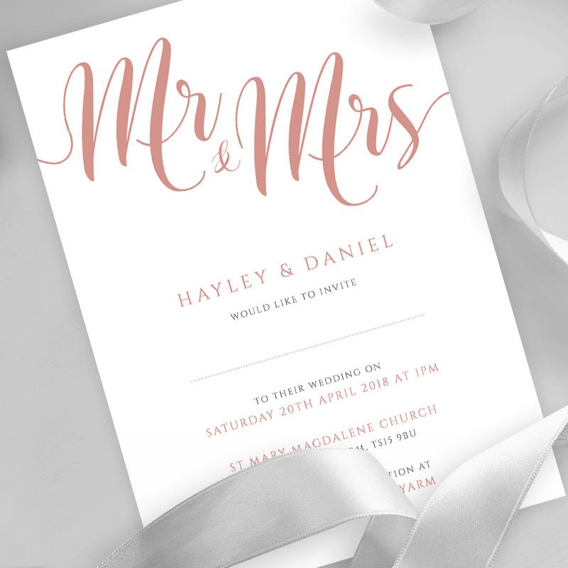 peach wedding invitation printed on white card with ribbons overlayed