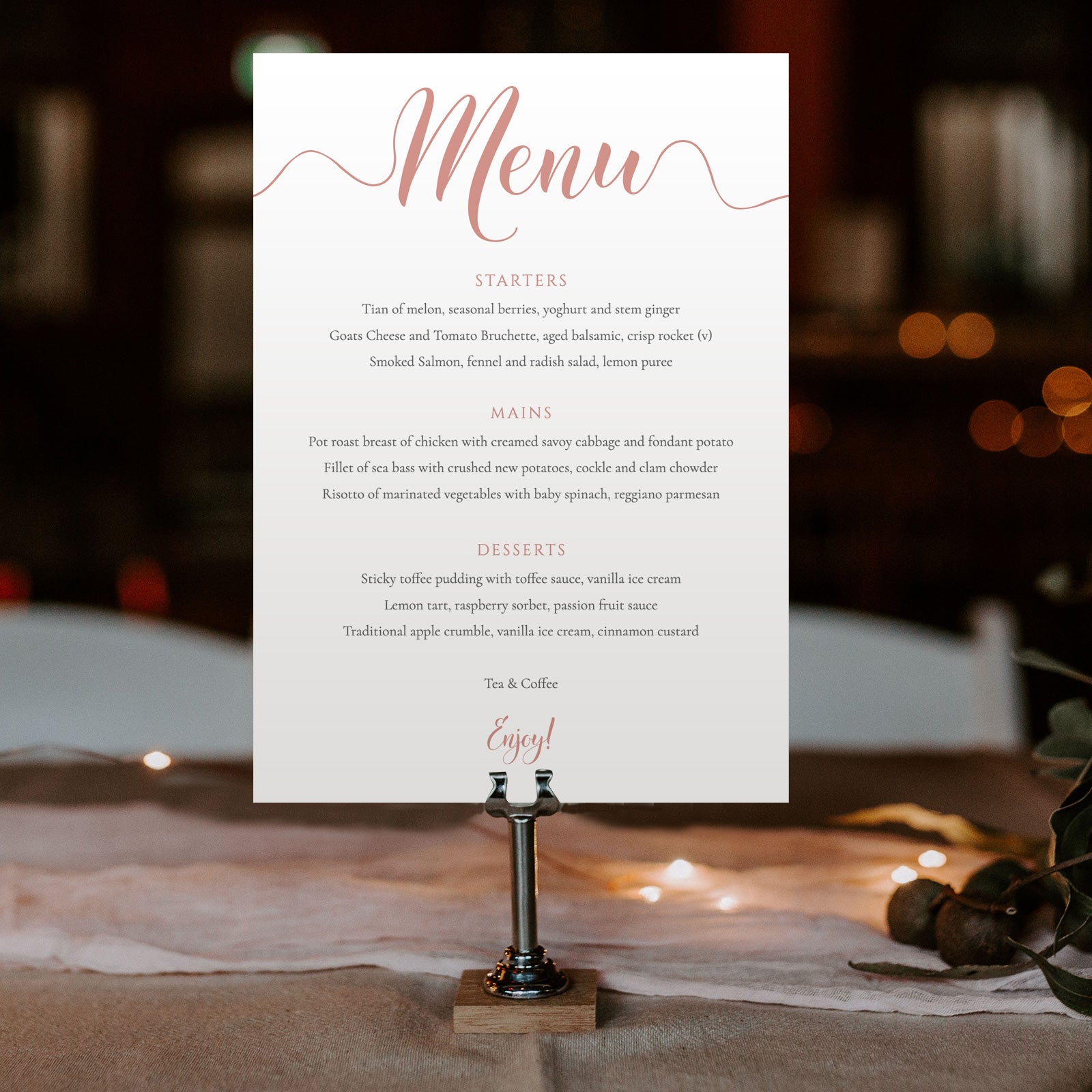 peach wedding menu card in a metal stand at an evening reception