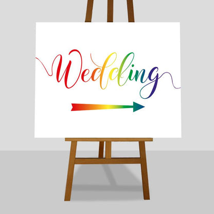 large rainbow wedding directions sign on an easel