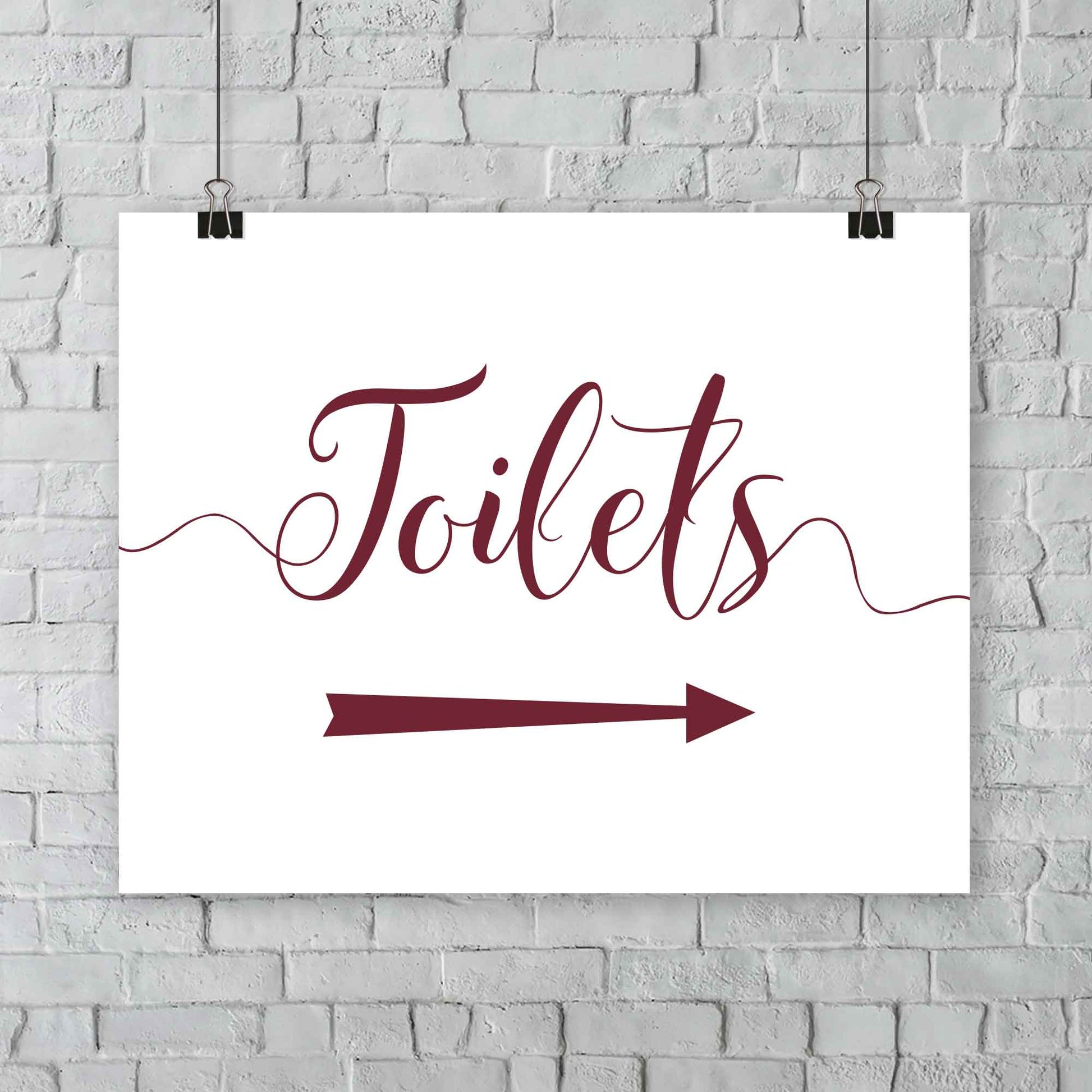 printed deep red wedding toilets arrow signage on a wall