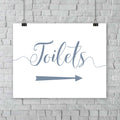 printed misty blue wedding toilets arrow signage on a wall