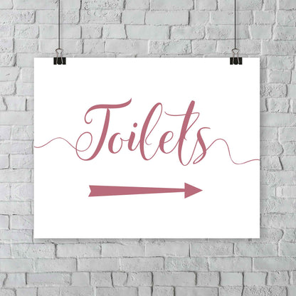 printed pastel pink wedding toilets arrow signage on a wall