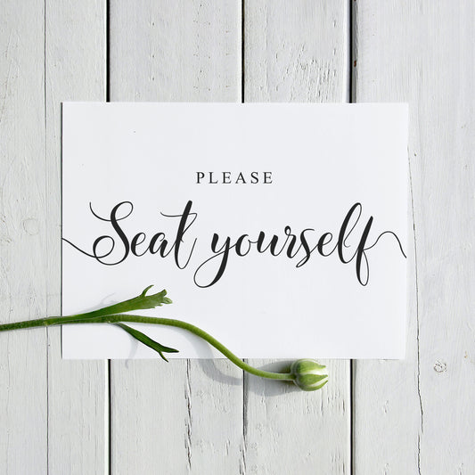Please seat yourself sign printed and placed on a wooden seat