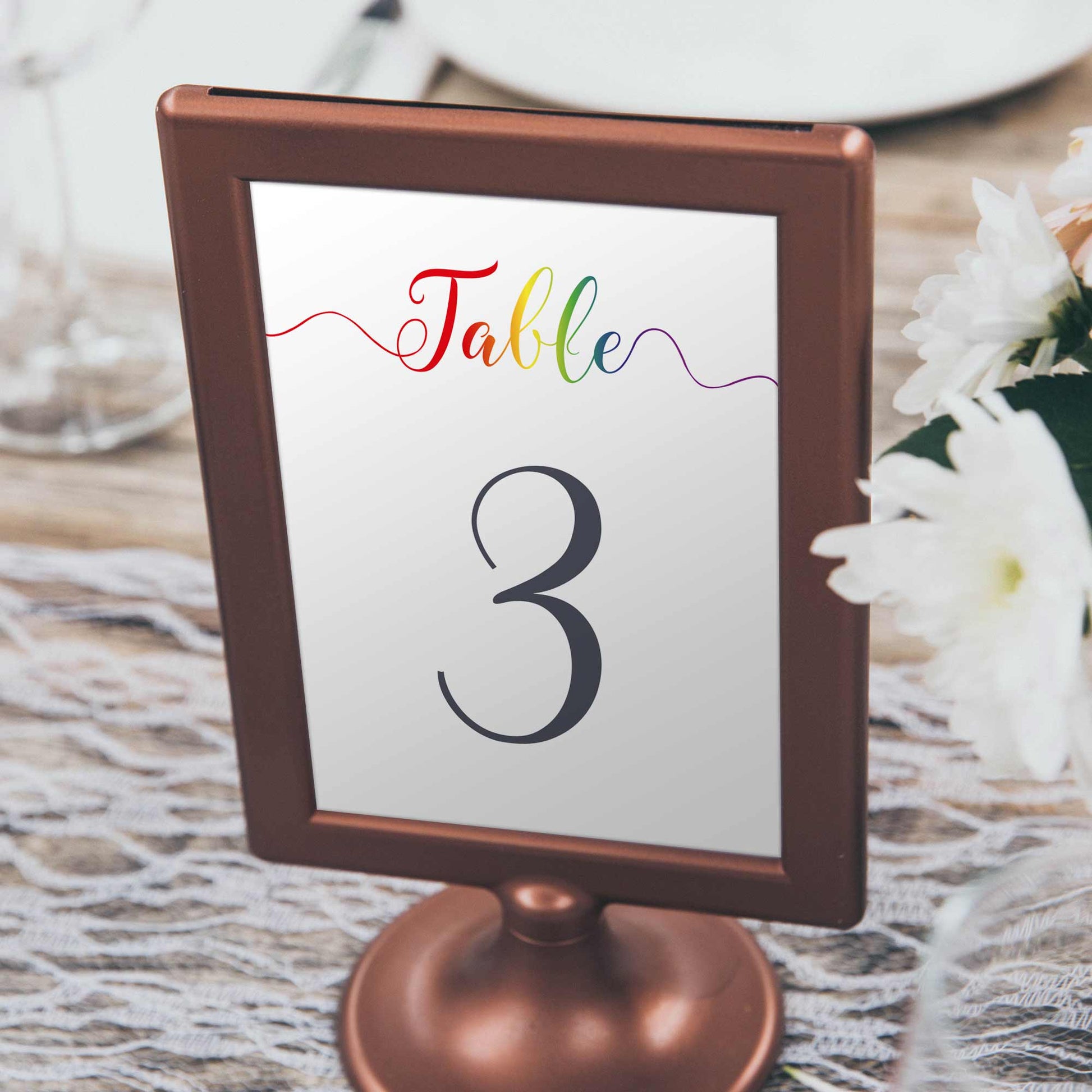 framed rainbow table number at a gay wedding