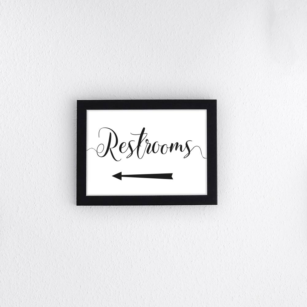 printed restrooms sign with directional arrow
