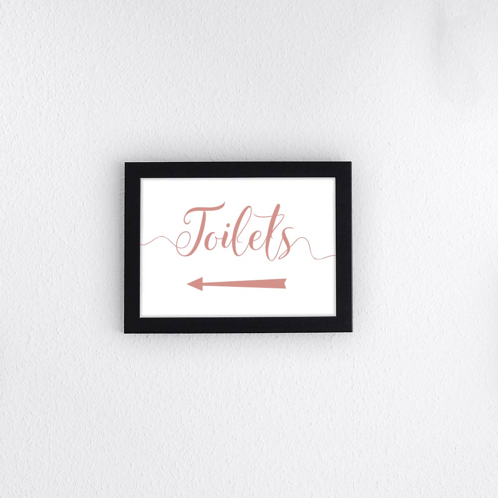 rose gold directional toilets sign with left arrow printed and framed