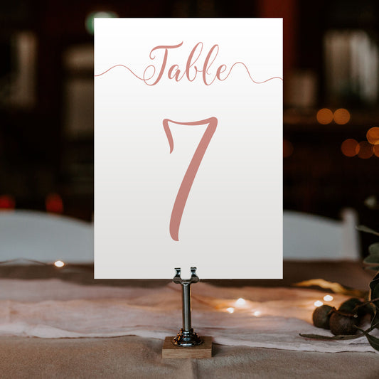 rose gold table number on a wedding table at an evening reception
