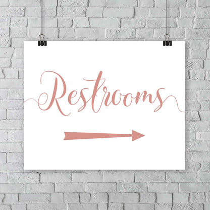 rose gold wedding restrooms arrow signage hanging from a wall