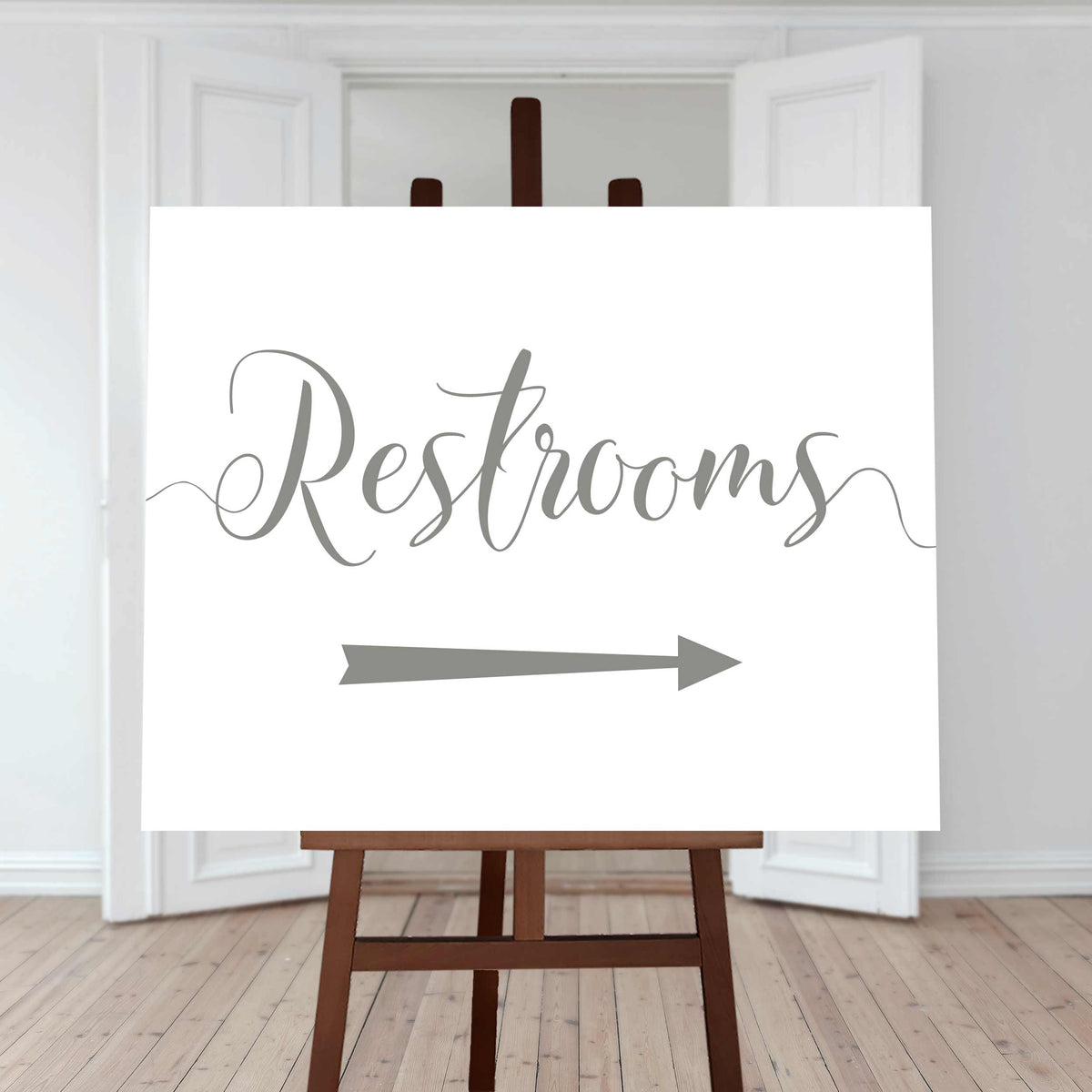sage green restroom directions sign with an arrow pointing right