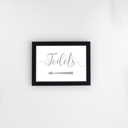 silver directional toilets sign with left arrow printed and framed