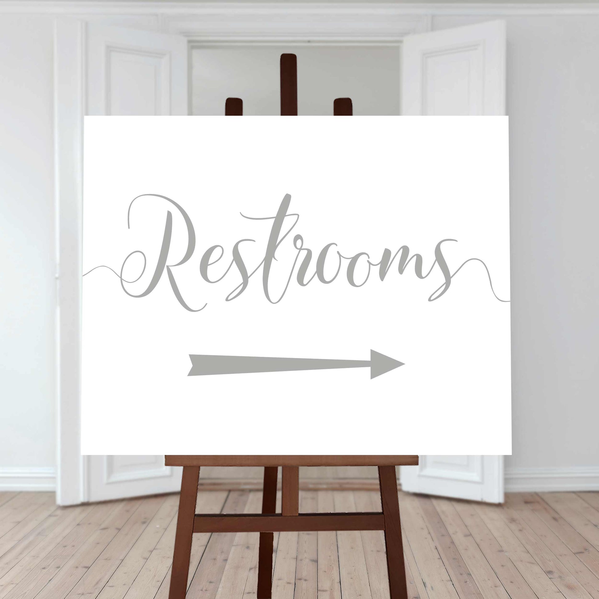 silver restroom directions sign with an arrow pointing right
