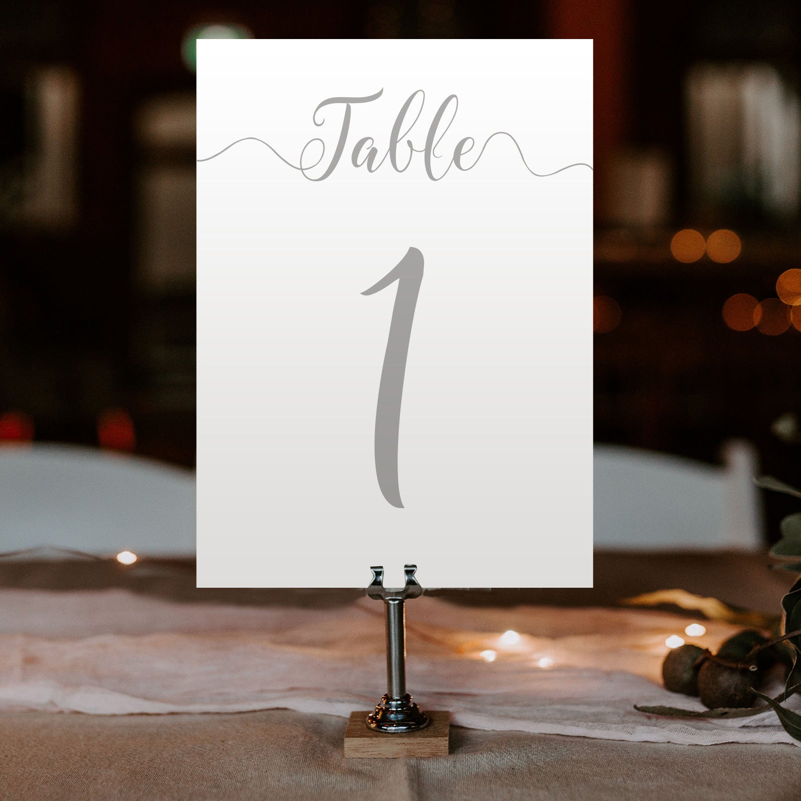 silver table number on a wedding table at an evening reception
