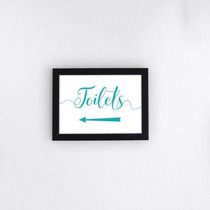 turquoise directional toilets sign with left arrow printed and framed