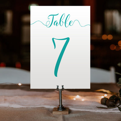 turquoise table number on a wedding table at an evening reception