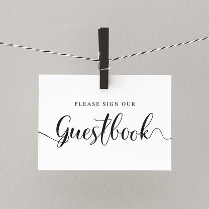Modern wedding guestbook sign hanging from a peg