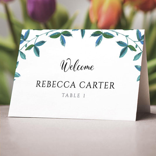 eucalyptus themed folded place card on a wedding table 