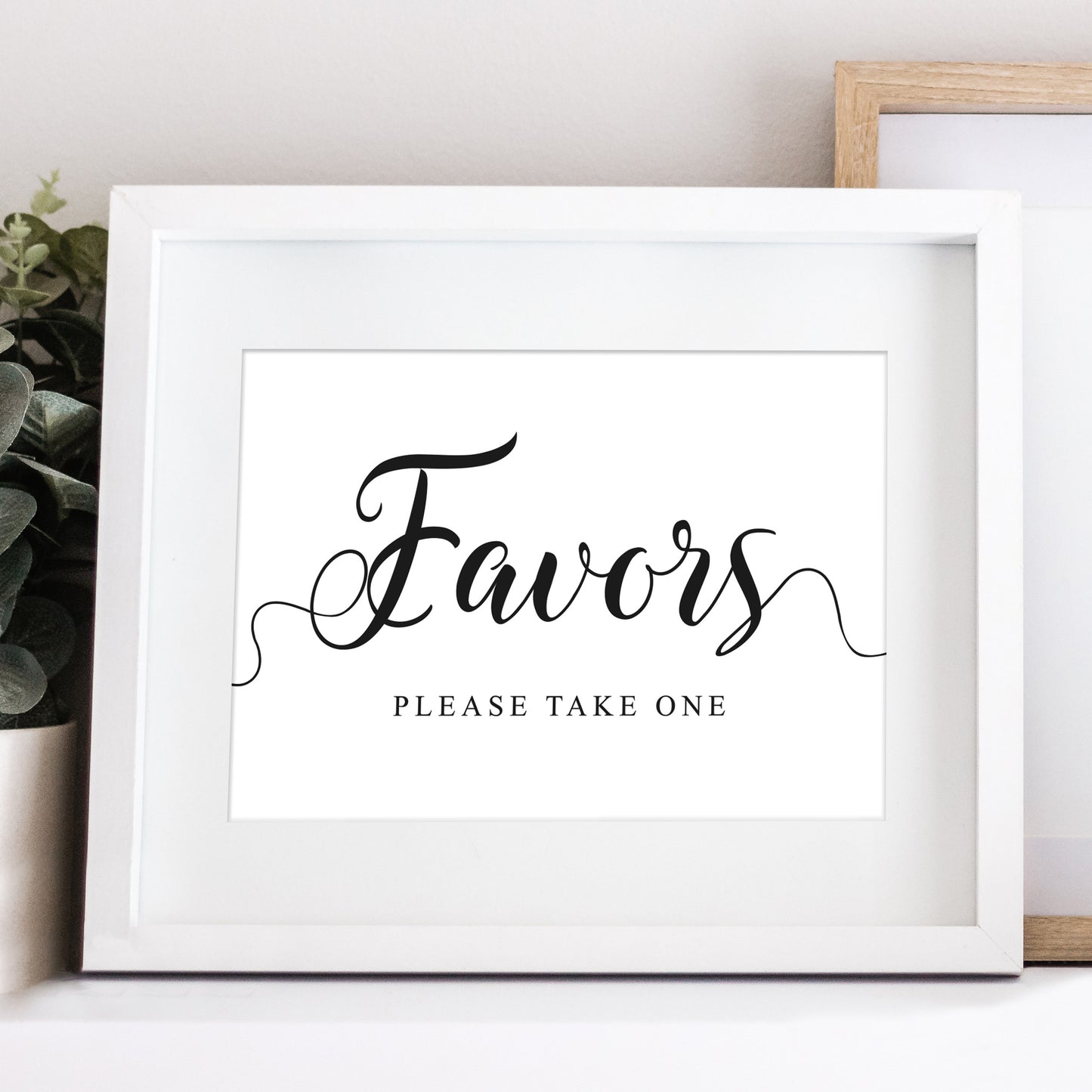 Wedding favors sign in a white frame on a table