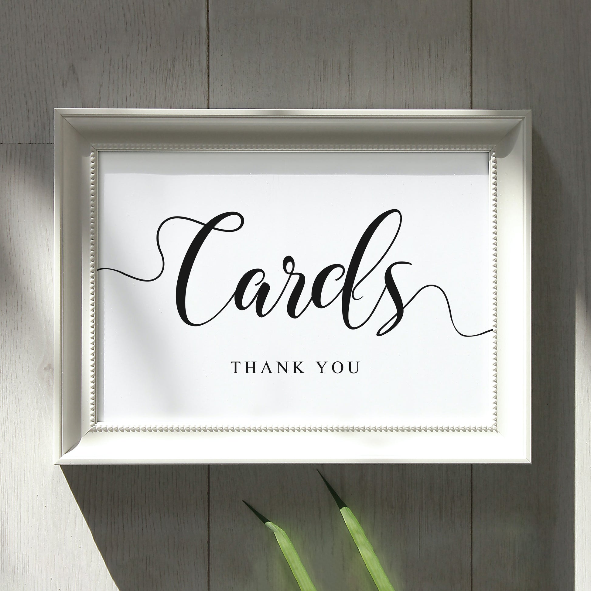 Elegant wedding cards sign, printed in white picture frame on rustic wall