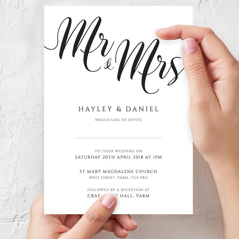 bride to be holding her printed mr and mrs wedding invitation